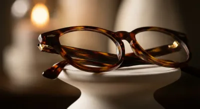 Gros plan minimaliste d'une monture de lunettes élégante sur fond épuré.