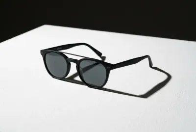 Paire de lunettes de soleil de vue posée sur un support minimaliste