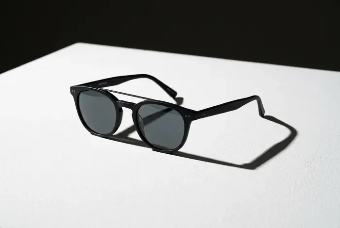 Paire de lunettes de soleil de vue posée sur un support minimaliste
