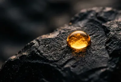 Goutte d'or sur fond noir minimaliste représentant la précision et la science médicale.