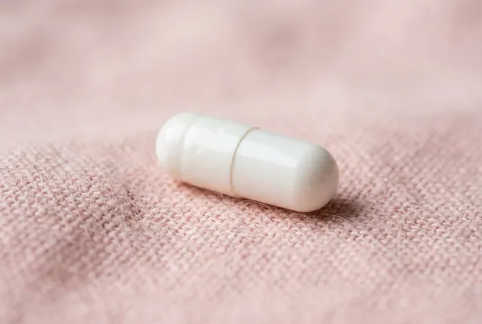 Est-ce que l'ésoméprazole fait grossir ? Analyse des effets Gros plan minimaliste d'une gélule sur un fond épuré