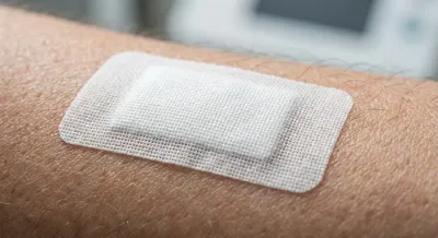 Gros plan sur un patch anti-douleur collé sur la peau.