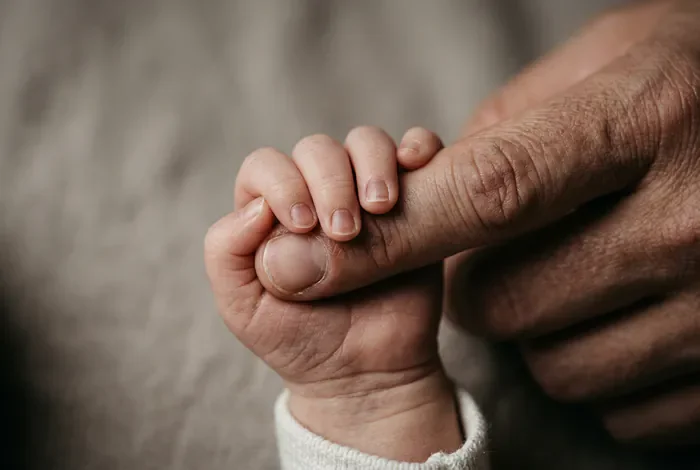 Main d'un nouveau-né saisissant le doigt d'un parent