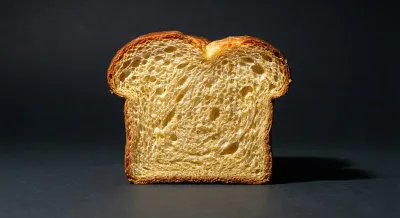 Gros plan minimaliste sur une tranche de brioche moelleuse avec un fort contraste