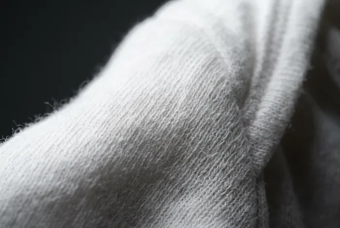 Gros plan minimaliste sur la texture d'un vêtement de bébé en coton