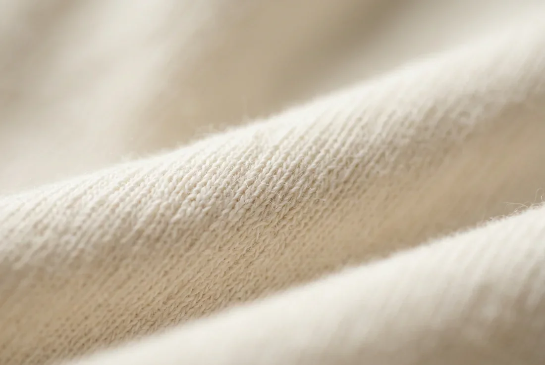 Un bébé paisible allongé sur des draps blancs baignés de lumière naturelle.